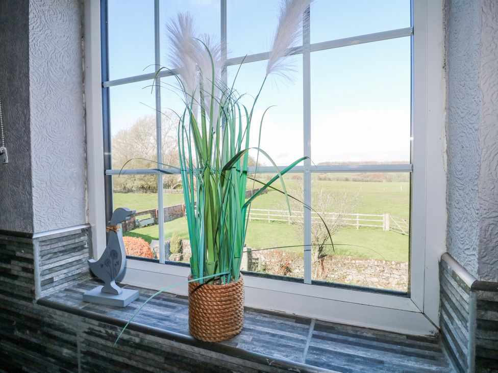 A window with a potted plant and a decorative figure at Ley Fields Farm Cheadle