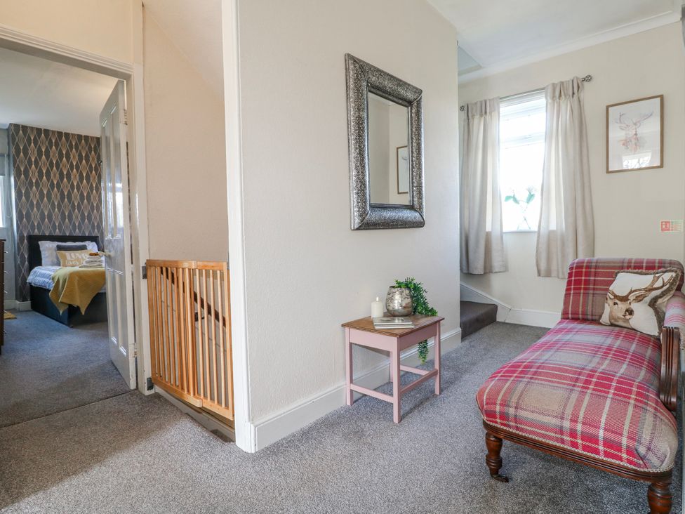 A hallway with a mirror and sofa at Ley Fields Farm in Cheadle