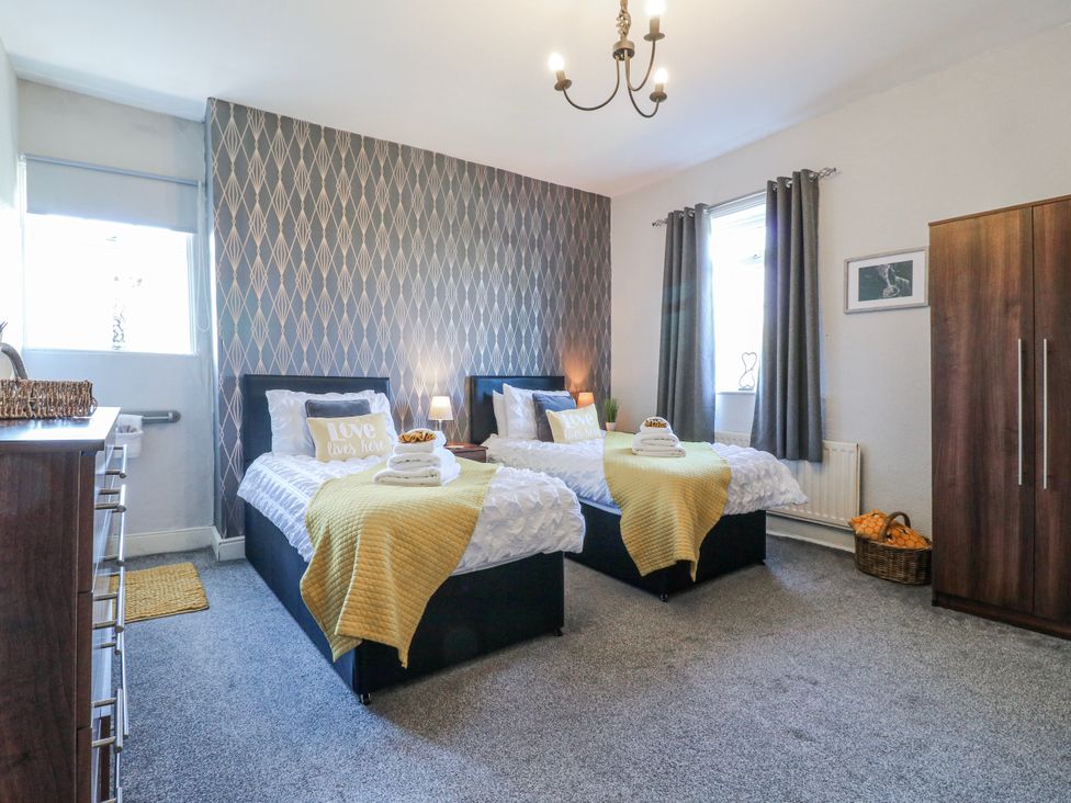 A bedroom with two beds and a wardrobe at Ley Fields Farm in Cheadle