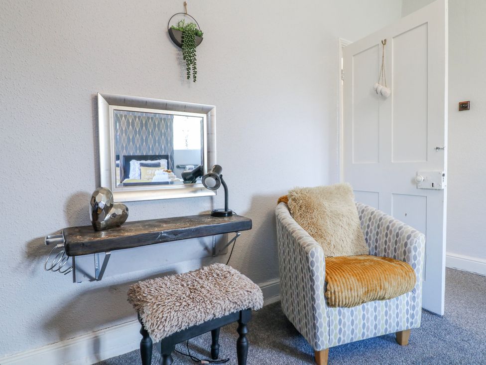 A living room with a mirror and chair at Ley Fields Farm in Cheadle