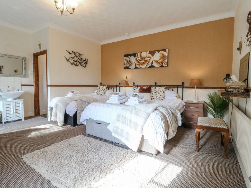 A bedroom with two beds and a mirror at Ley Fields Farm in Cheadle