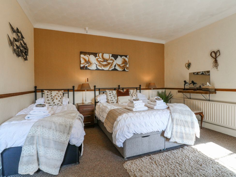 A bedroom with two beds and a bedside table at Ley Fields Farm in Cheadle