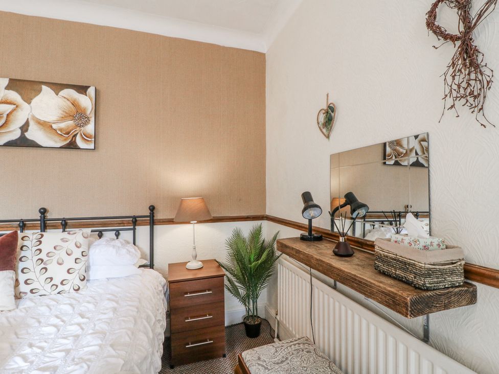 A bedroom with a bed, nightstand, and mirror at Ley Fields Farm in Cheadle