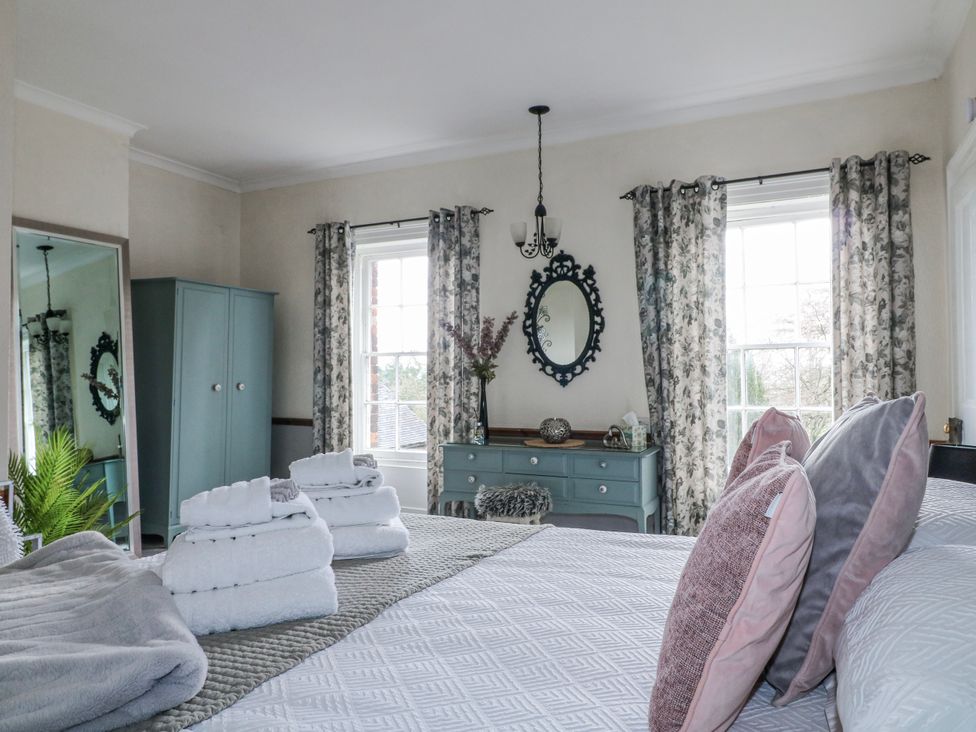 A bedroom featuring a bed with towels and a dresser at Ley Fields Farm in Cheadle