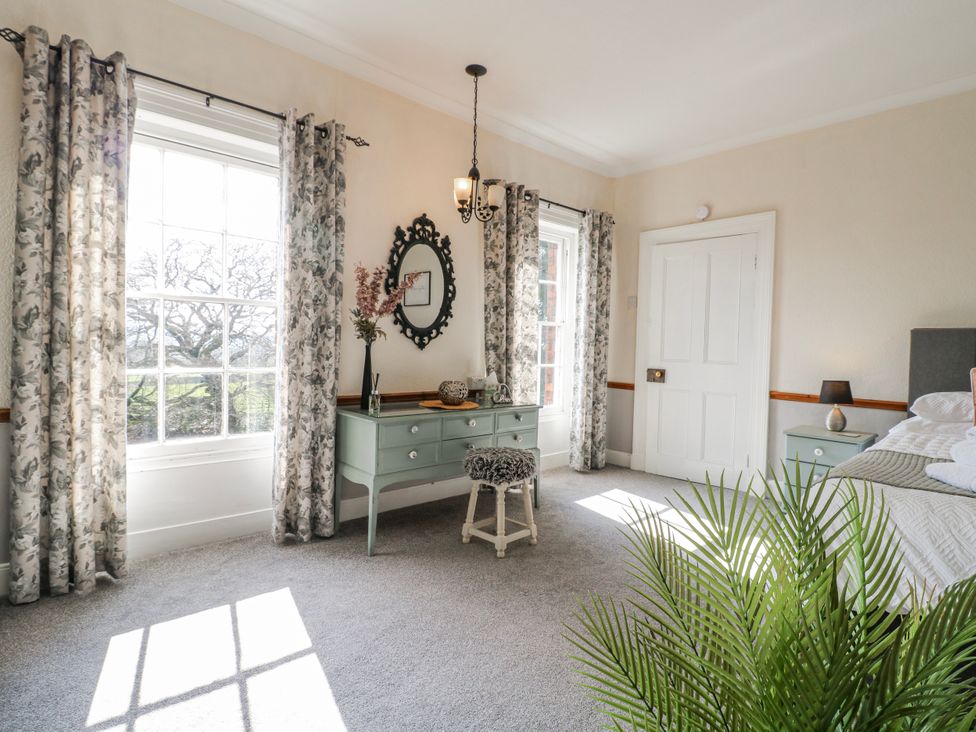 A bedroom with a dresser and mirror at Ley Fields Farm in Cheadle