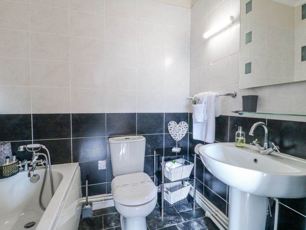 A bathroom with a bathtub, toilet, and sink at Ley Fields Farm Cheadle