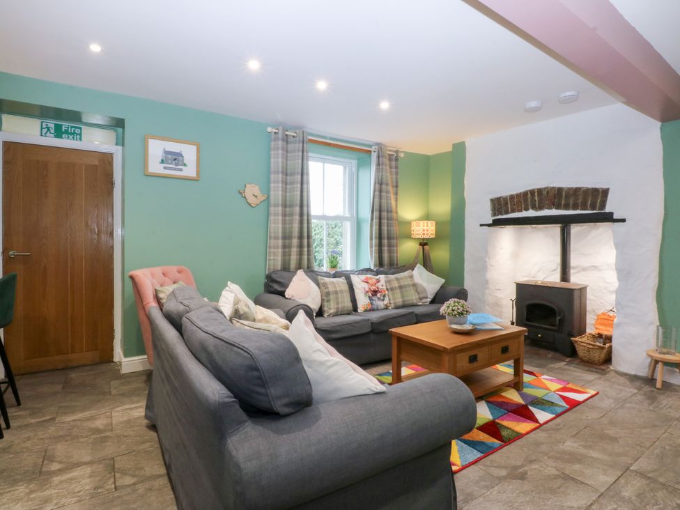 A living room with a sofa and coffee table at Tregynrig Bach in Cemaes Bay