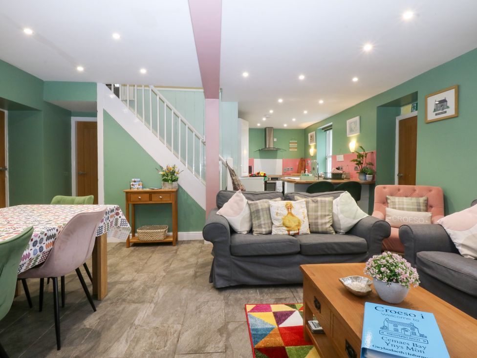 A living room with a sofa and dining table at Tregynrig Bach in Cemaes Bay