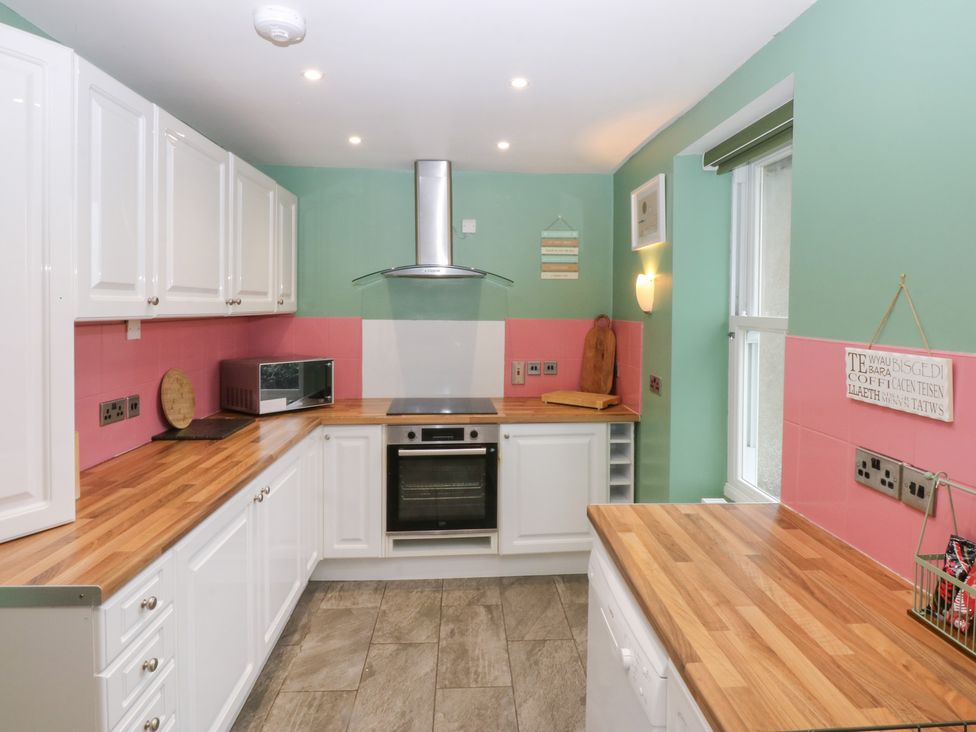 A kitchen with cabinets, microwave, and oven at Tregynrig Bach in Cemaes Bay