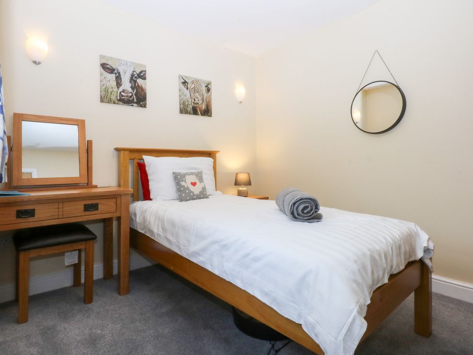 A bedroom with a bed and dressing table at Tregynrig Bach in Cemaes Bay