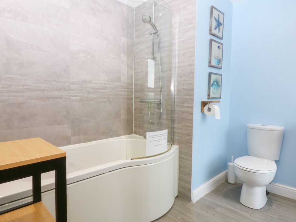 A bathroom with a bath tub and toilet at Tregynrig Bach in Cemaes Bay