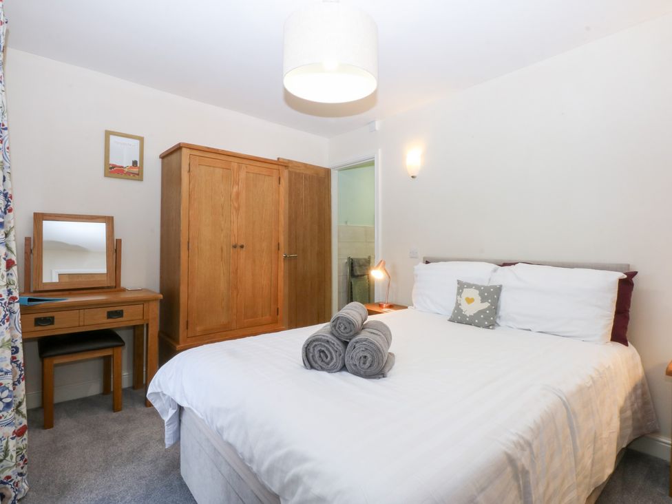 A bedroom with a bed and a wardrobe at Tregynrig Bach in Cemaes Bay