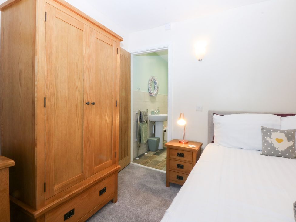 A bedroom with a wardrobe and bed at Tregynrig Bach Cemaes Bay