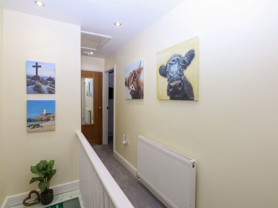A hallway with pictures on the wall at Tregynrig Bach in Cemaes Bay