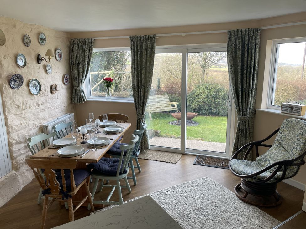 A dining room with a table set for meals at Penllain, Newport, Pembrokeshire