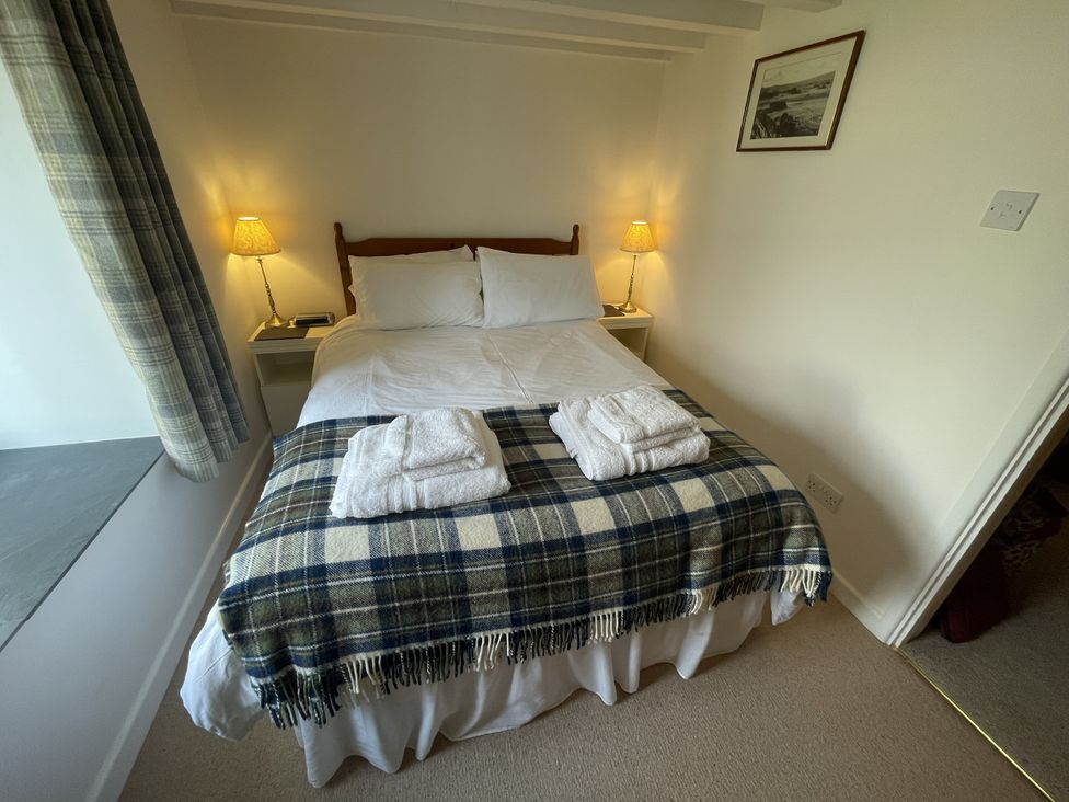 A bedroom with a double bed and towels at Penllain in Newport, Pembrokeshire