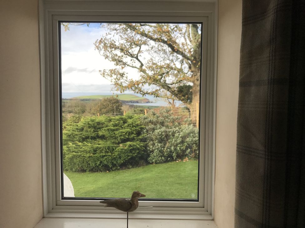 A view from a window with a bird figurine in a living room at Penllain, Newport, Pembrokeshire