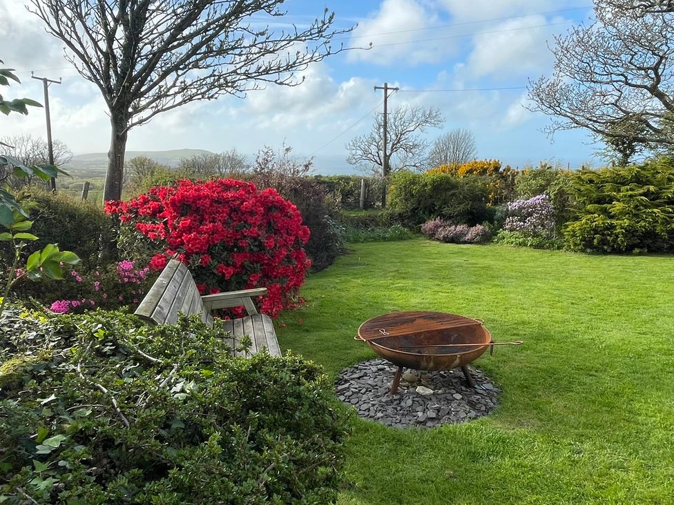 A garden with a bench and a fire pit at Penllain, Newport, Pembrokeshire