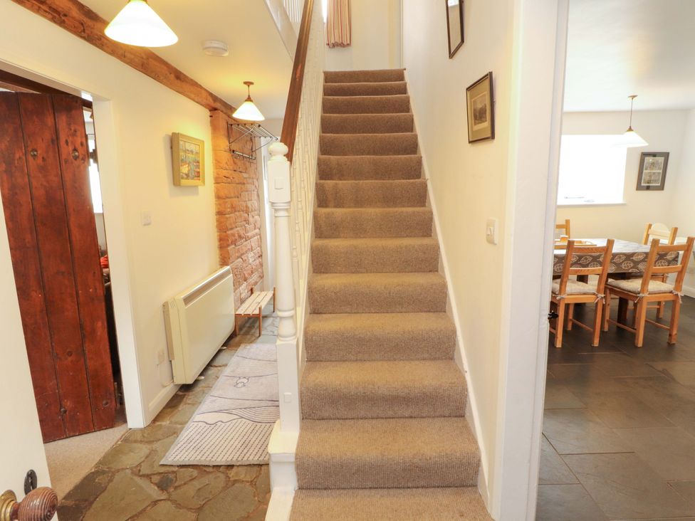 A hallway with stairs and a dining area at One Town End in Mungrisdale, Mosedale