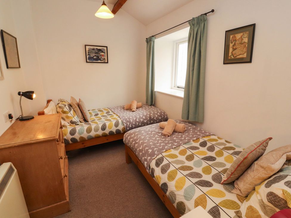 A bedroom with twin beds and a lamp at One Town End, Mungrisdale, Mosedale