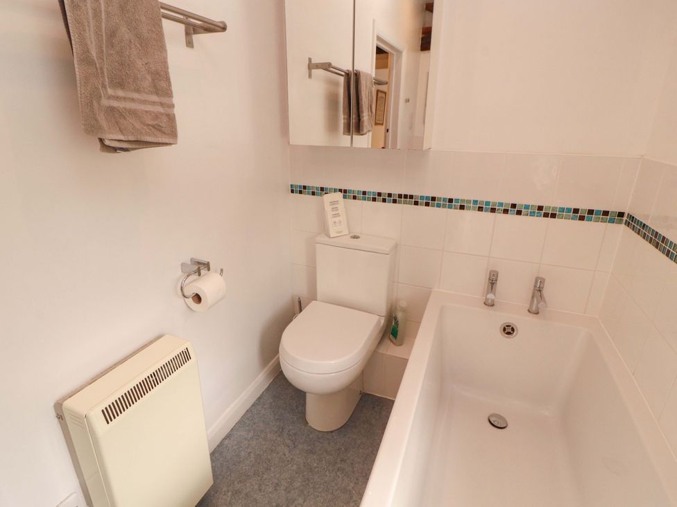 A bathroom with a toilet, bathtub, and sink at One Town End, Mungrisdale, Mosedale