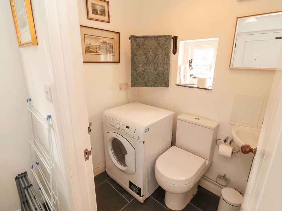 A bathroom with a washing machine and toilet at One Town End in Mungrisdale, Mosedale