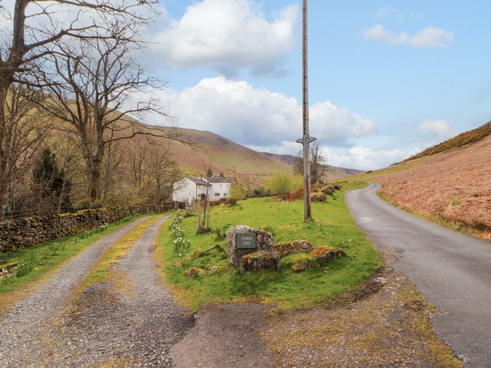 A rural road junction with a house and a sign at One Town End in Mungrisdale, Mosedale