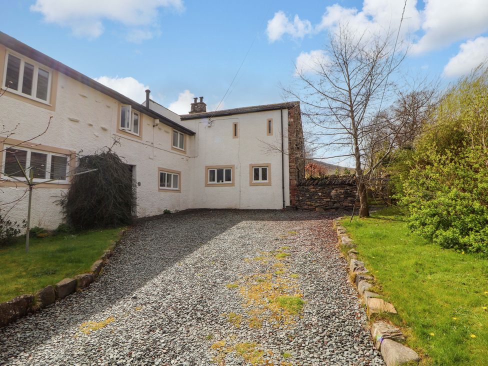A garden with a gravel driveway and building at One Town End, Mungrisdale, Mosedale