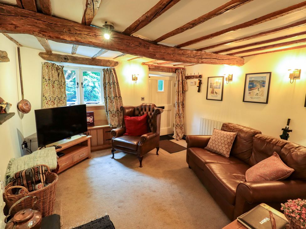A living room with a television and sofas at Fellside Cottage in Bowness-On-Windermere