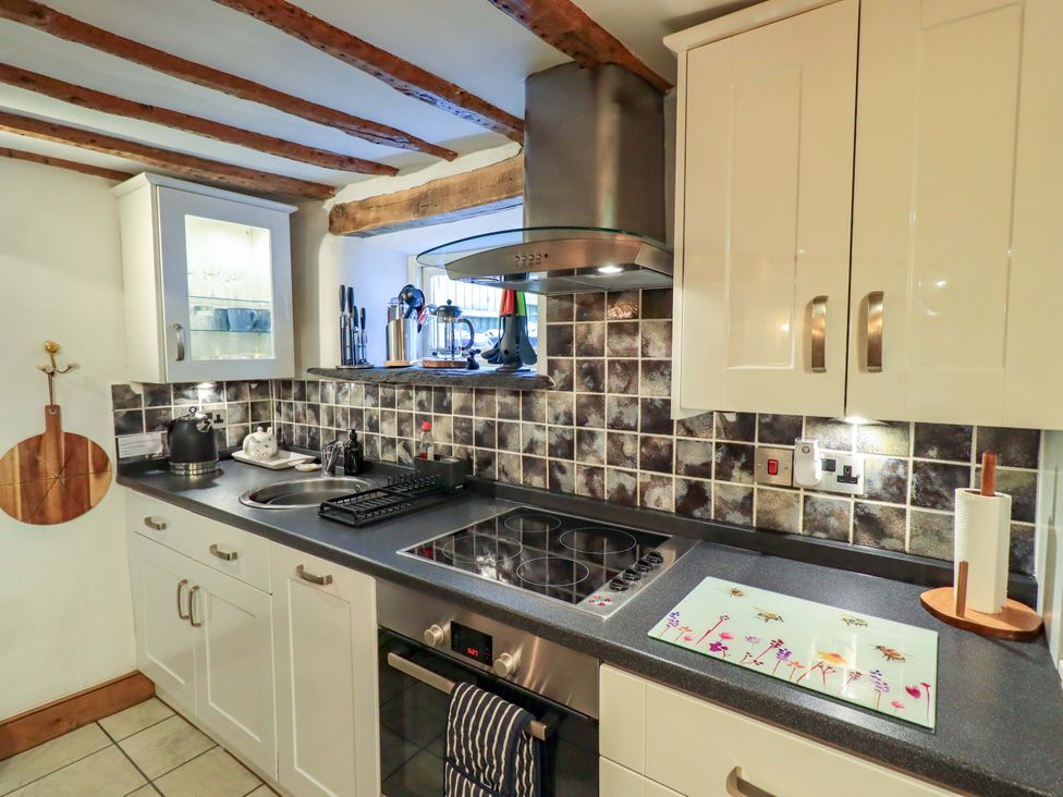 A kitchen with a stove and sink at Fellside Cottage Bowness-On-Windermere
