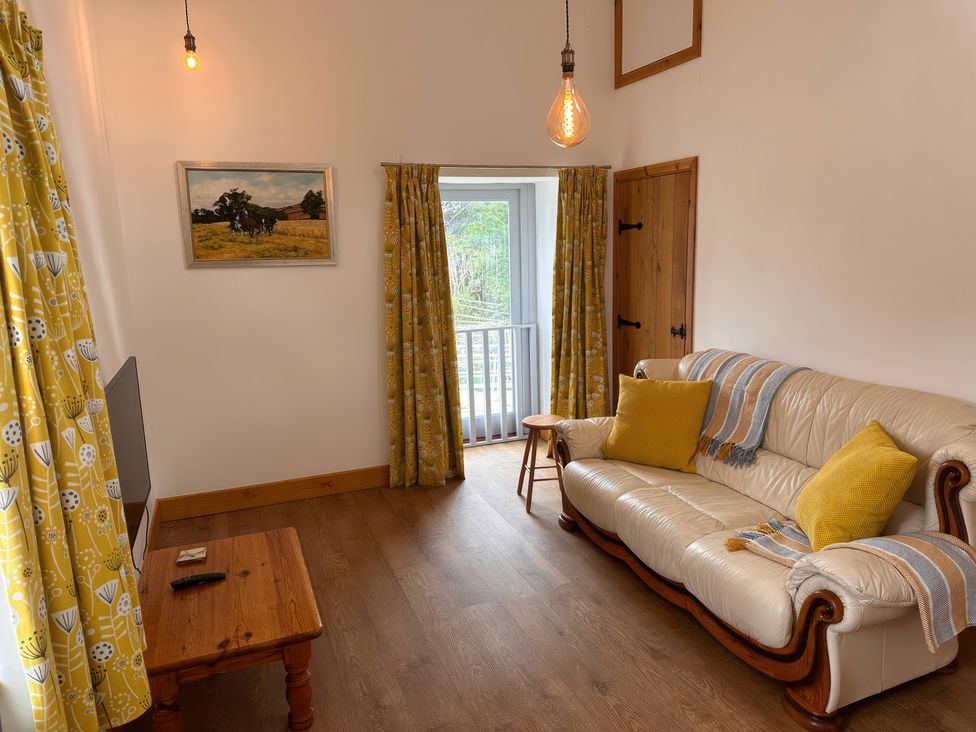 A living room with a sofa and coffee table at Shires Rest in Puxey near Sturminster Newton