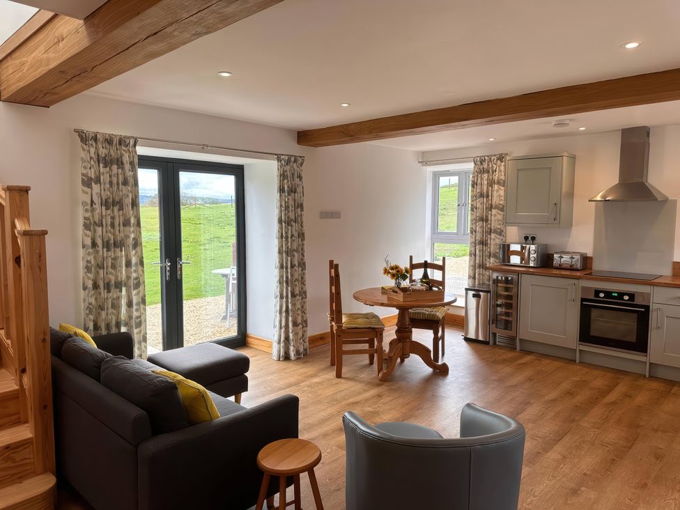 A living room and kitchen with a dining table and sofa at Shires Rest Puxey near Sturminster Newton