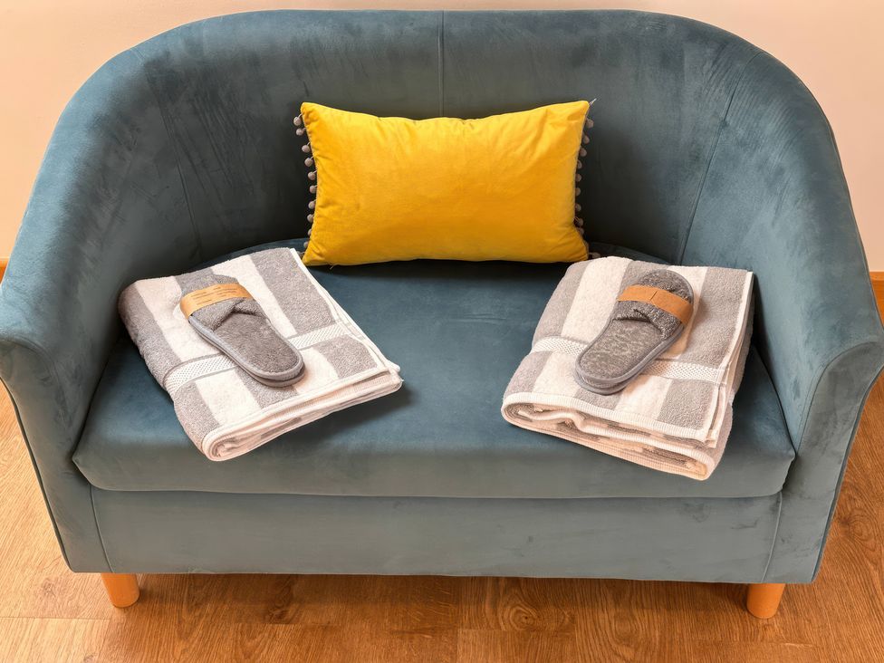 A sofa with towels and slippers at Shires Rest in Puxey near Sturminster Newton