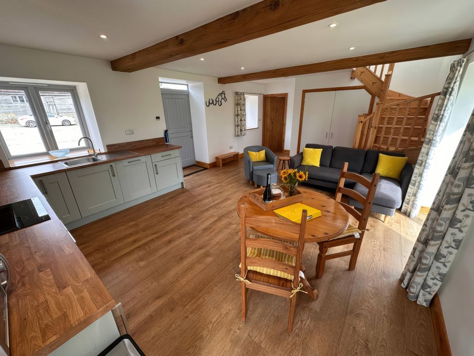 A living room with a kitchen area and dining table at Shires Rest Puxey near Sturminster Newton