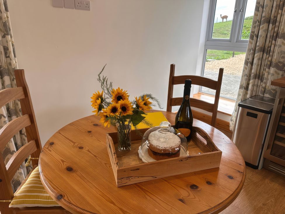 A dining room with a table set for two at Shires Rest in Puxey near Sturminster Newton