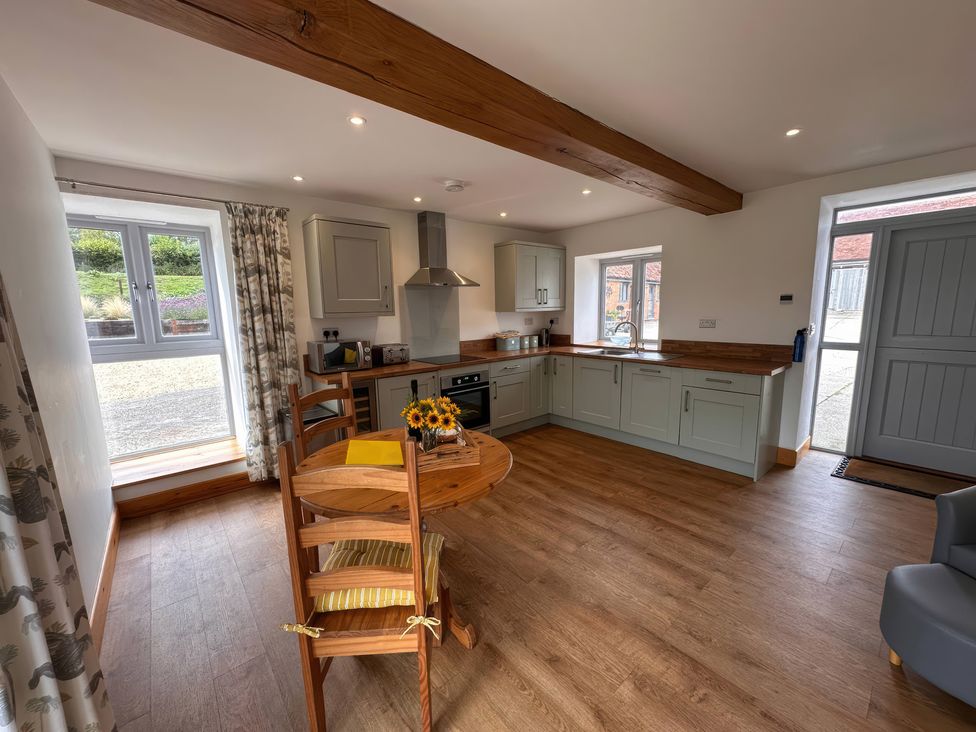 A kitchen with a round table and chairs at Shires Rest in Puxey near Sturminster Newton