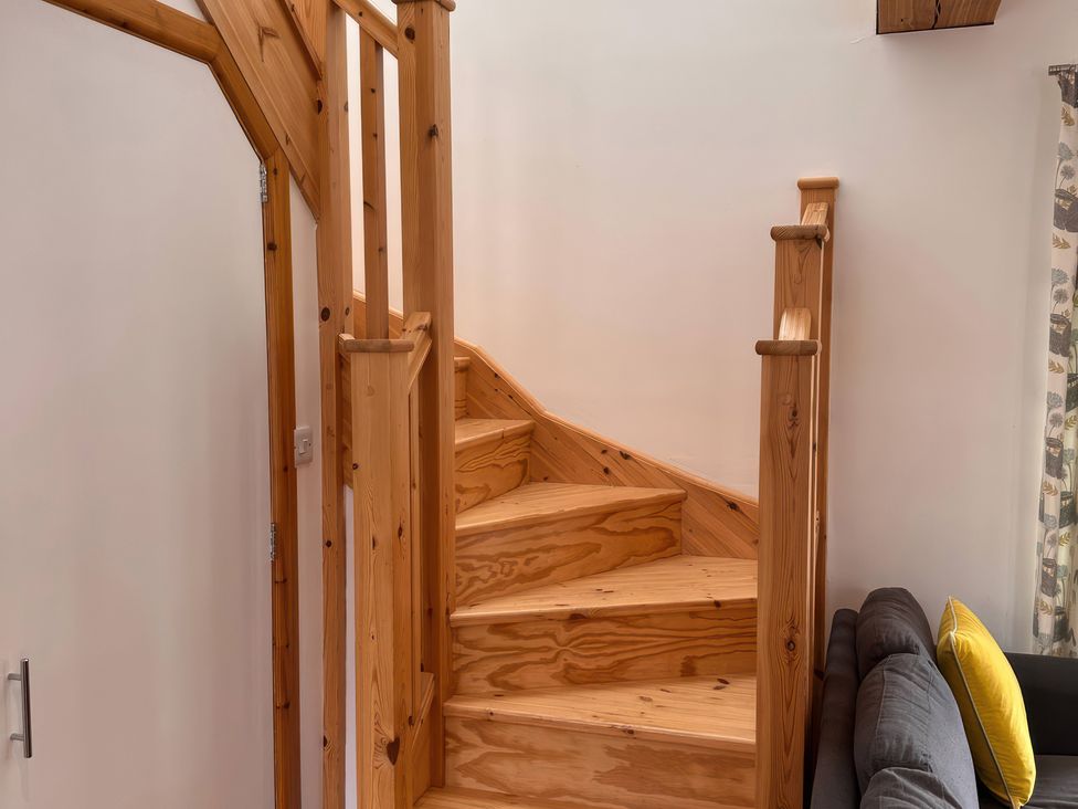 A staircase with a wooden banister in a living room at Shires Rest Puxey near Sturminster Newton