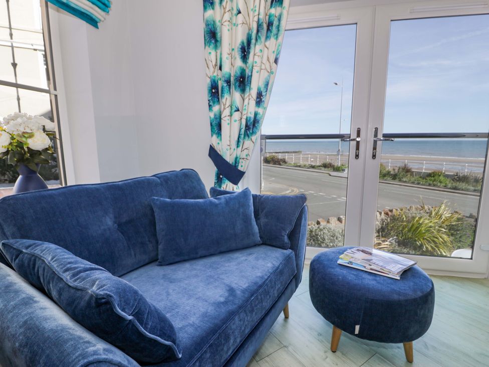 A living room with a sofa and view of the sea at Ocean View Apartment in Colwyn Bay