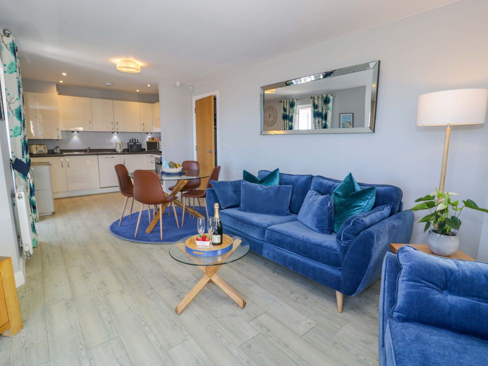 A living room with a sofa and dining area at Ocean View Apartment in Colwyn Bay