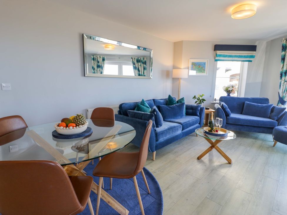A living room with a dining table and sofas at Ocean View Apartment in Colwyn Bay