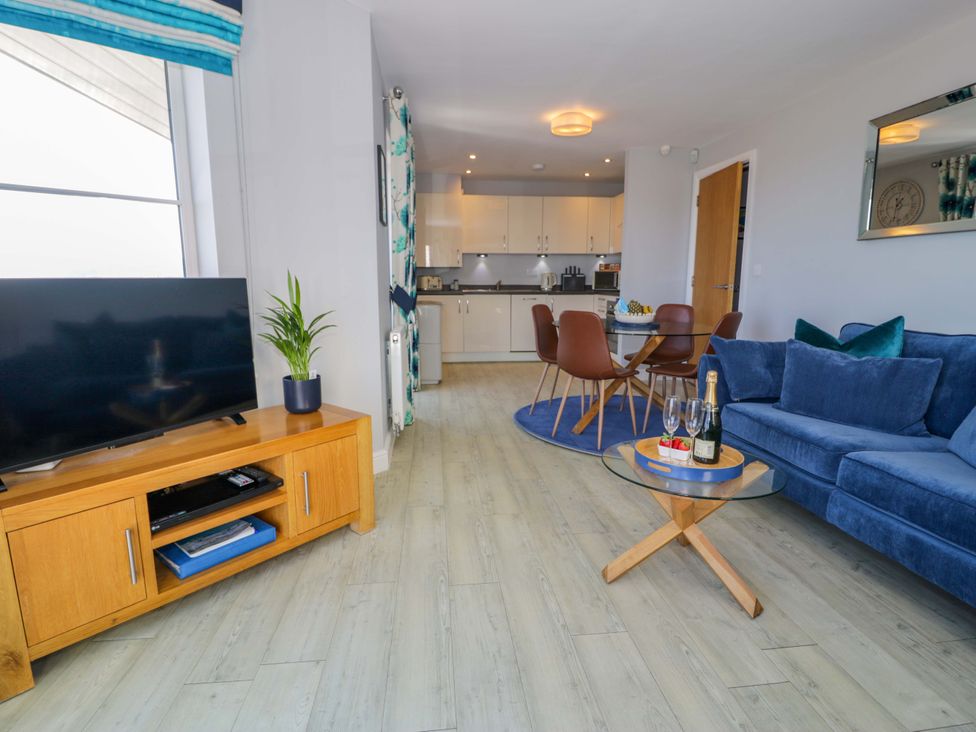 A living room with a sofa and television at Ocean View Apartment in Colwyn Bay