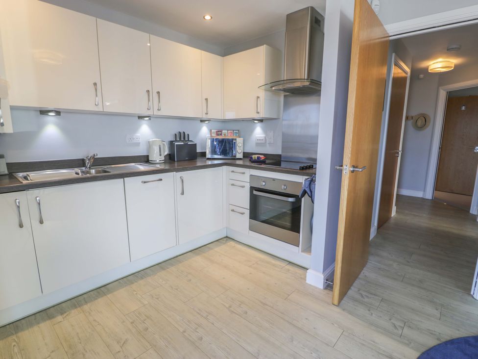 A kitchen with appliances and cabinets at Ocean View Apartment in Colwyn Bay