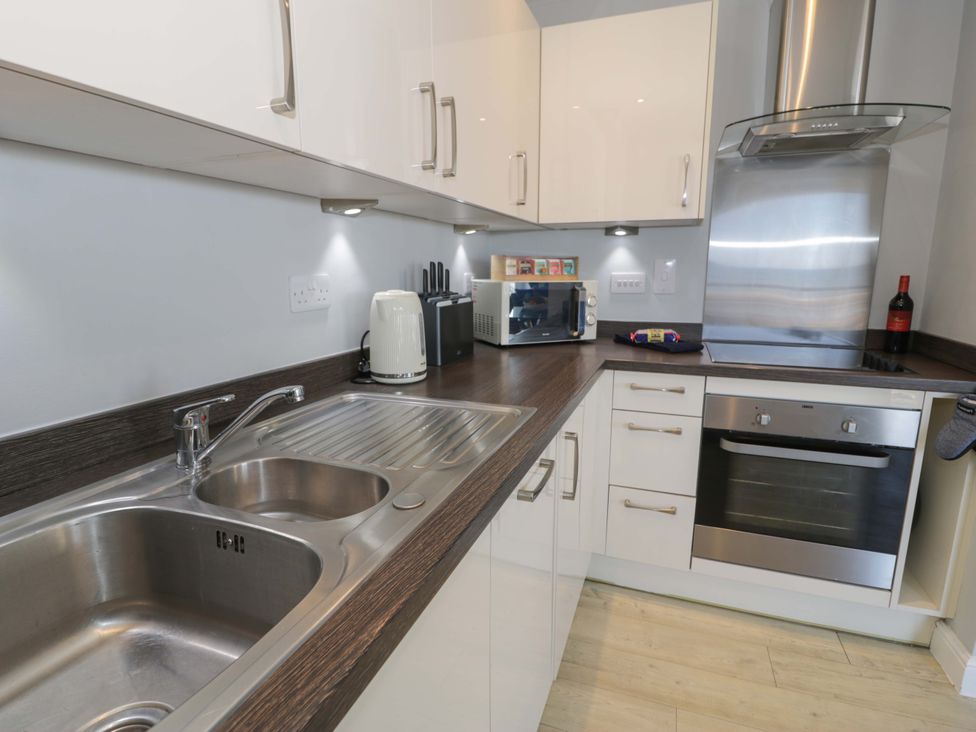 A kitchen with a sink and oven at Ocean View Apartment in Colwyn Bay