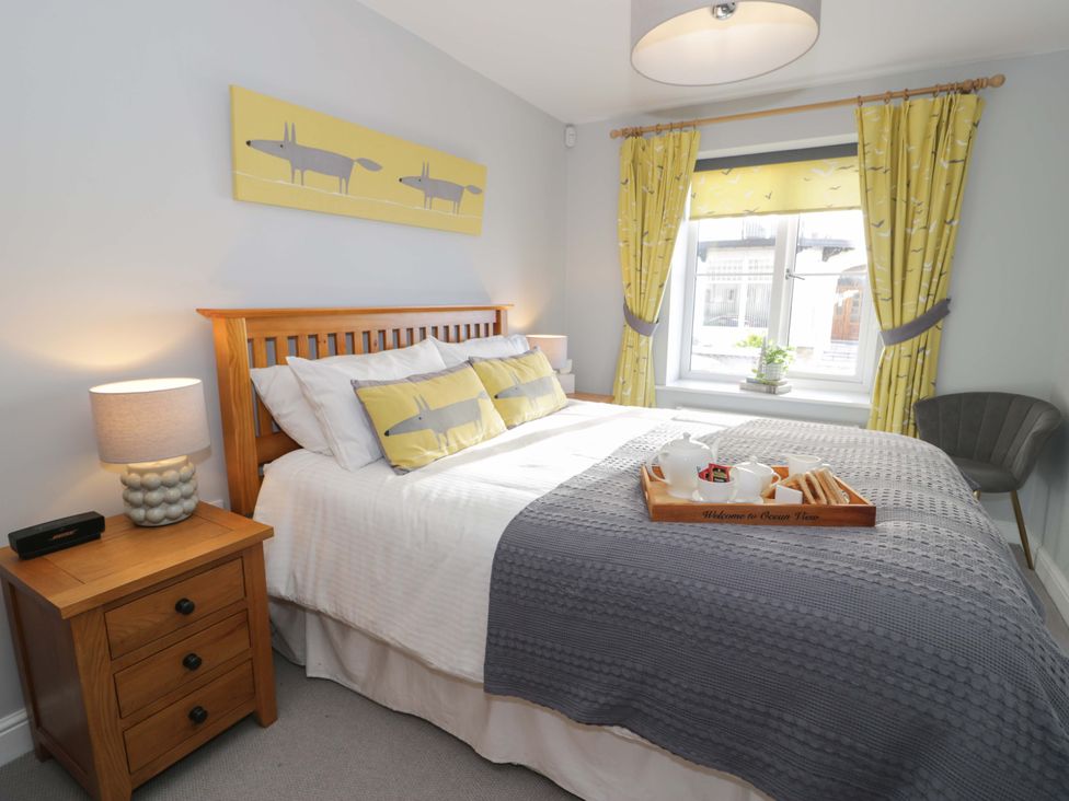 A bedroom with a bed and nightstand at Ocean View Apartment in Colwyn Bay