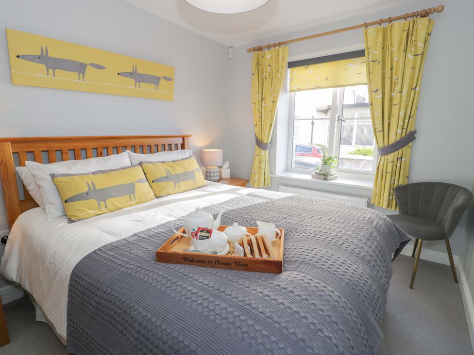 A bedroom with a bed and chair at Ocean View Apartment in Colwyn Bay