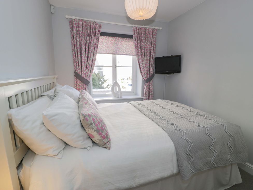 A bedroom with a bed and television at Ocean View Apartment in Colwyn Bay