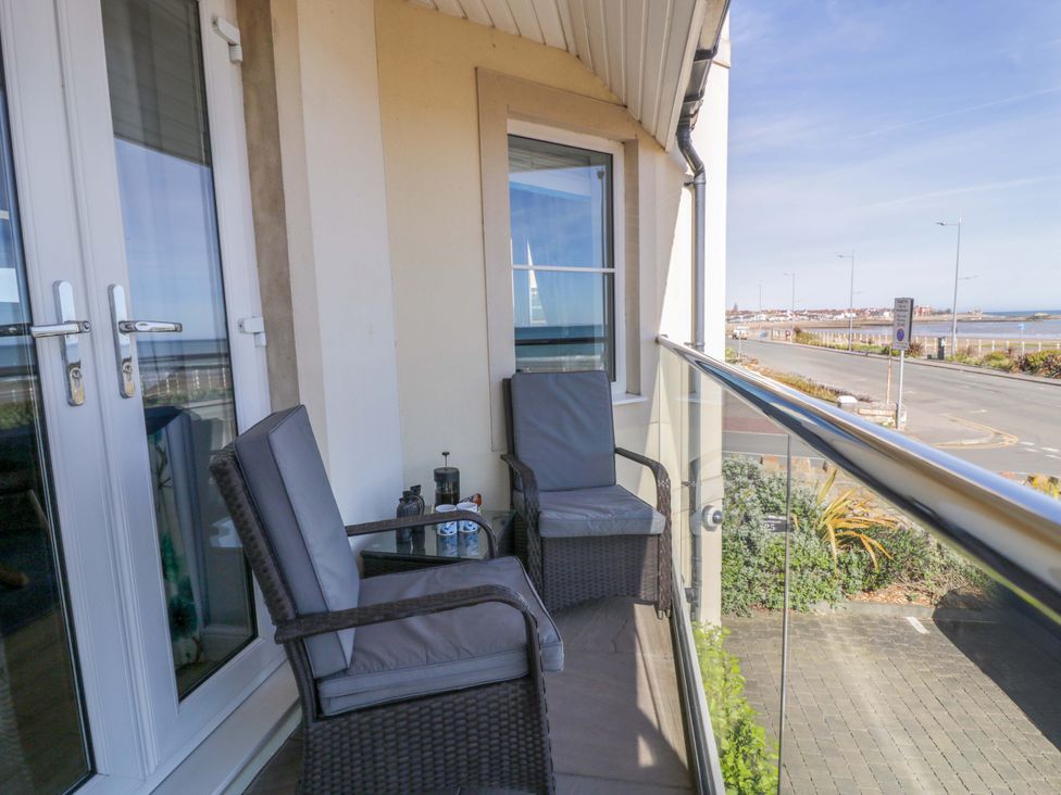 A balcony with two chairs and a table at Ocean View Apartment in Colwyn Bay