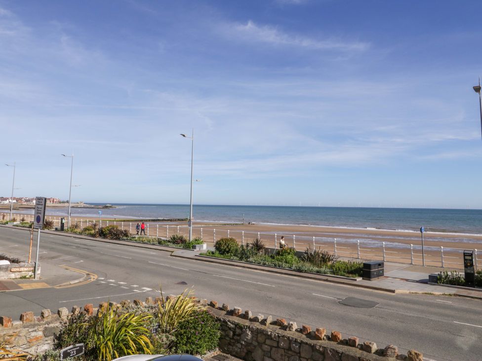 A view of the sea and beach with people walking at Ocean View Apartment in Colwyn Bay