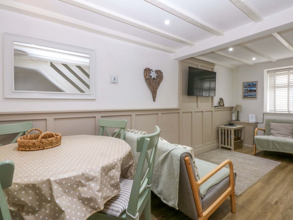 A living room with a dining table and chairs at 27 Kingshead Street Pwllheli