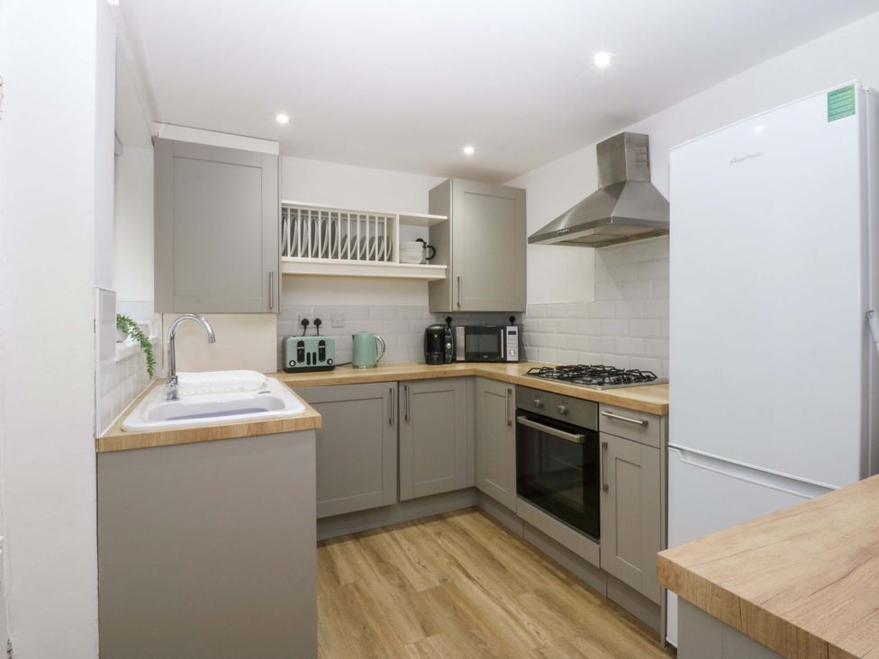 A kitchen with cabinets, appliances and wooden countertops at 27 Kingshead Street Pwllheli